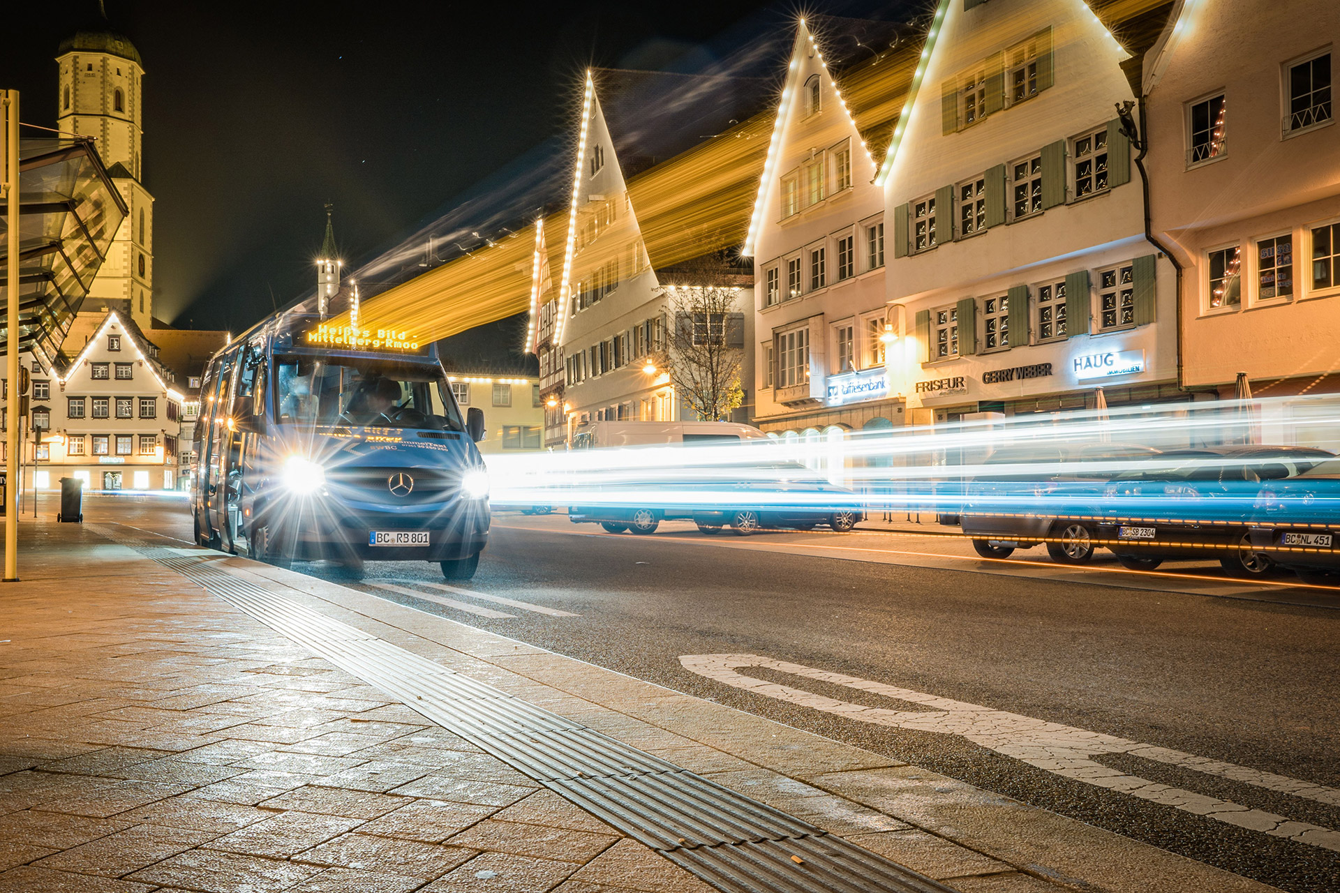 Tankkarten können kleinen Unternehmen helfen, Tank-, Lade- und weitere Mobilitätskosten zentral und übersichtlich zu verwalten. Transporter fährt nachts durch eine beleuchtete Innenstadt